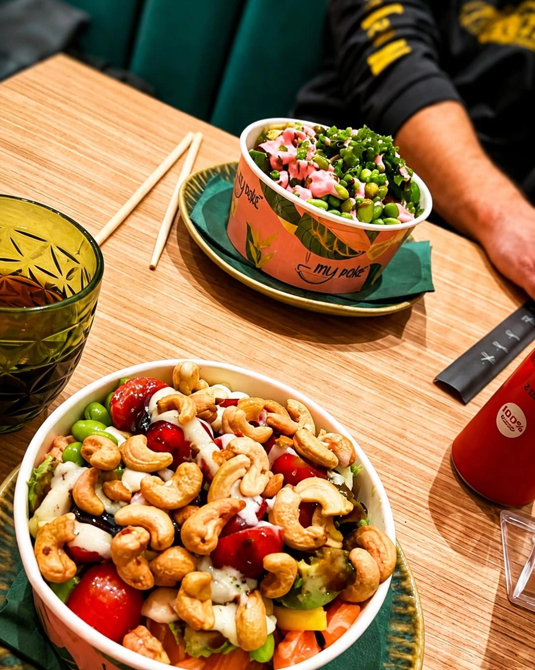 Due bowl My Pokè servite al tavolo, una con edamame e piselli, l'altra con anacardi e pomodorini